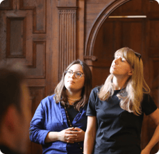 Two female members of the Tumelo team listening and observing at a team event.